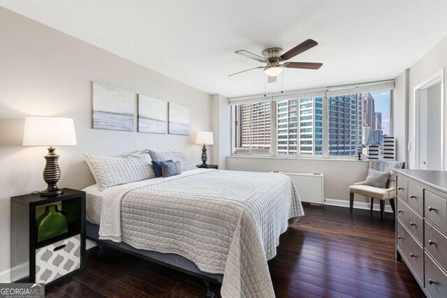 bedroom with radiator, dark wood-type flooring, and ceiling fan