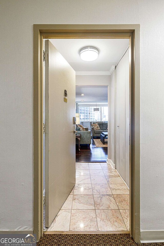 corridor featuring light wood-type flooring and ornamental molding