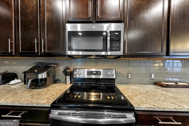 kitchen with appliances with stainless steel finishes, dark brown cabinets, backsplash, and light stone counters