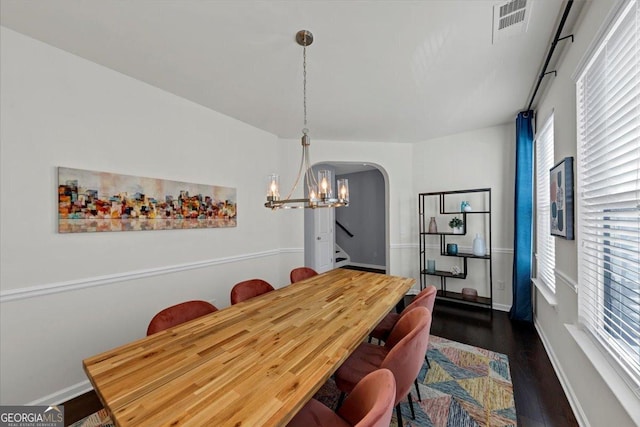 dining room with dark wood-type flooring and a chandelier