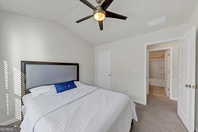 carpeted bedroom featuring ceiling fan, vaulted ceiling, and ensuite bathroom