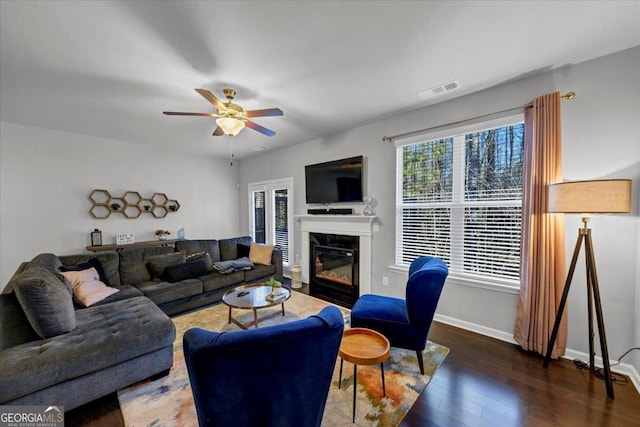 living room with ceiling fan, a fireplace, and dark hardwood / wood-style floors