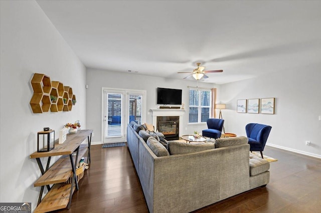 living room featuring dark wood-type flooring and ceiling fan