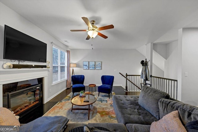 living room with ceiling fan, dark hardwood / wood-style flooring, and lofted ceiling