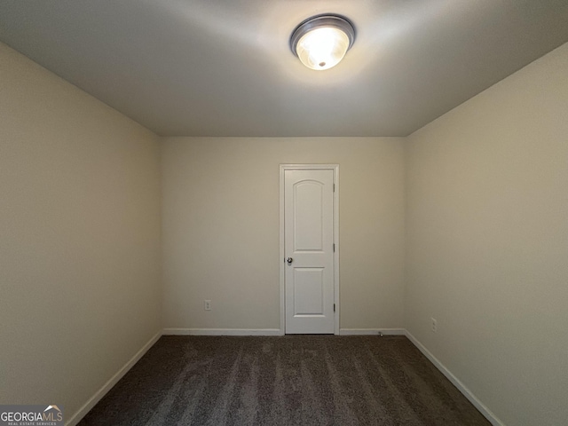 spare room featuring dark carpet