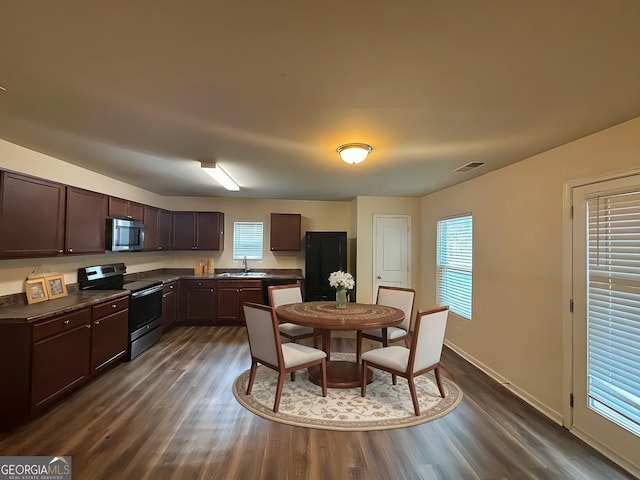 kitchen with stainless steel appliances, dark wood-type flooring, dark brown cabinets, and sink