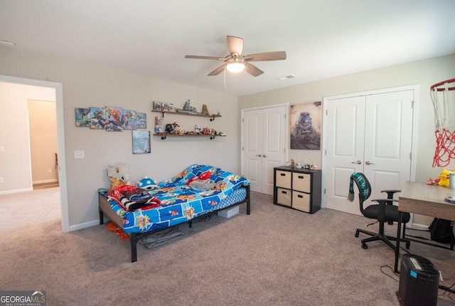 carpeted bedroom featuring ceiling fan and multiple closets