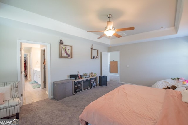 bedroom with a raised ceiling, ceiling fan, and light carpet