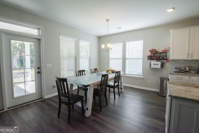 dining room with dark hardwood / wood-style flooring and a chandelier