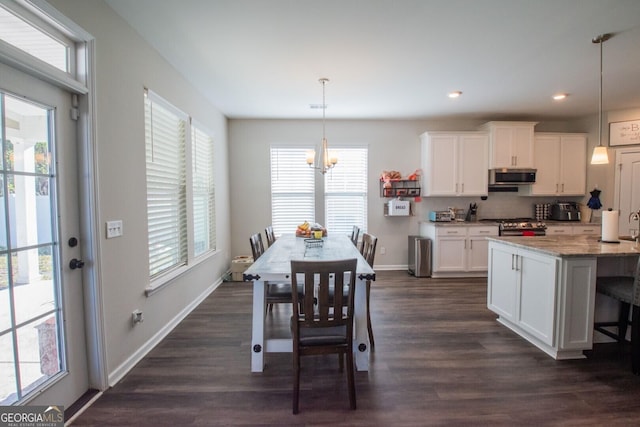 dining area featuring dark hardwood / wood-style flooring, a wealth of natural light, and a chandelier