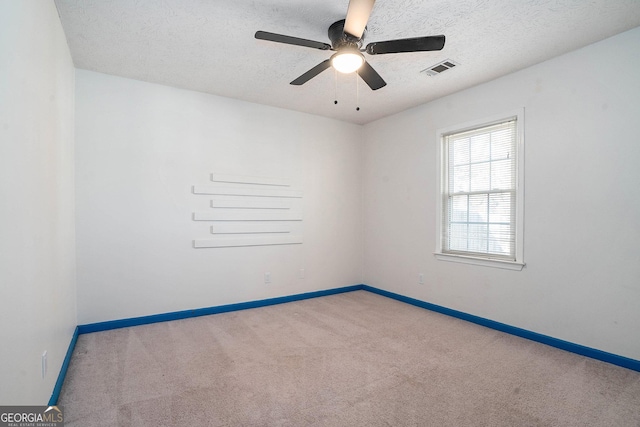 empty room with a textured ceiling, carpet floors, and ceiling fan