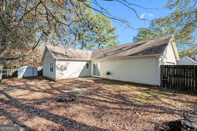 rear view of house featuring a storage shed