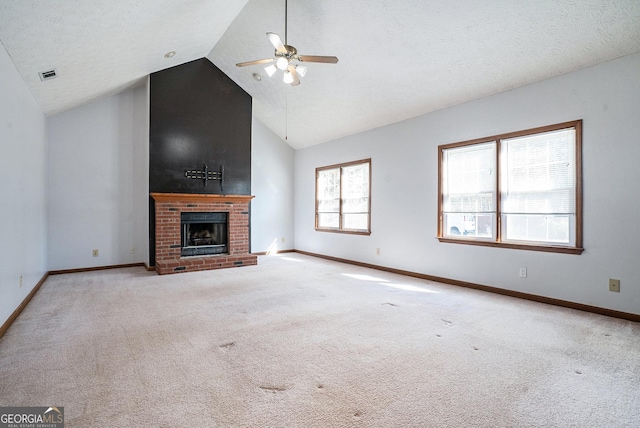 unfurnished living room featuring ceiling fan, light colored carpet, a fireplace, and a wealth of natural light