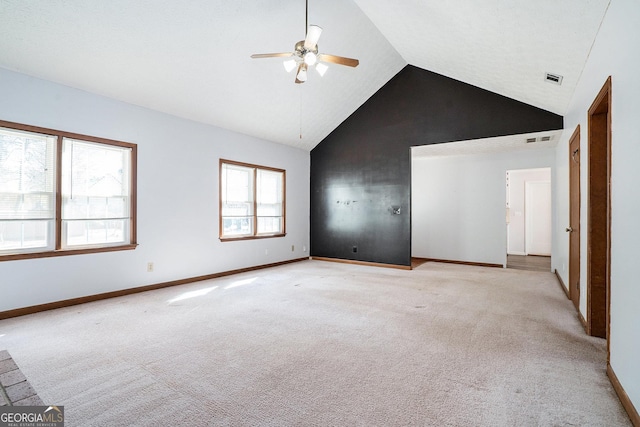 empty room featuring ceiling fan, light carpet, and high vaulted ceiling