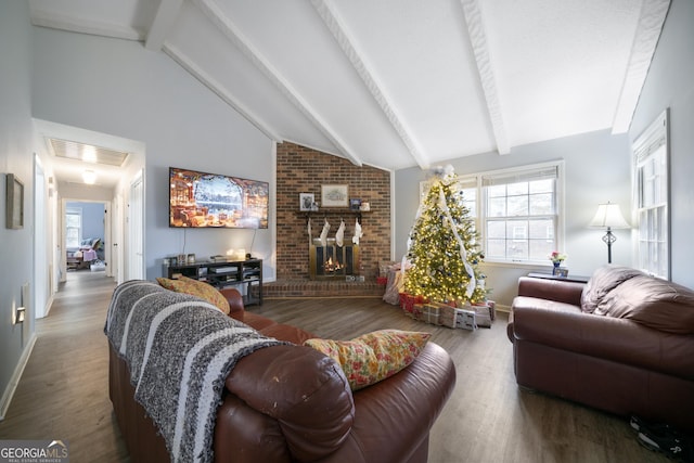 living room featuring beamed ceiling, high vaulted ceiling, hardwood / wood-style flooring, and a brick fireplace