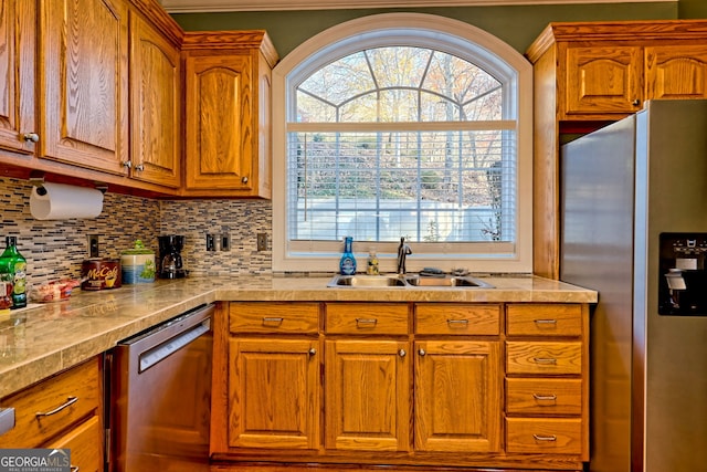 kitchen with backsplash, appliances with stainless steel finishes, and sink