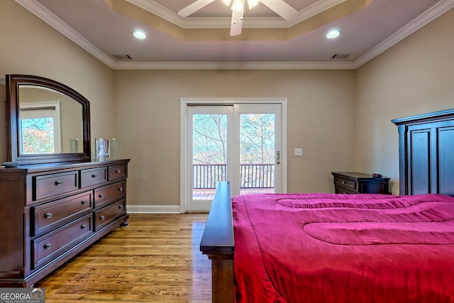 bedroom featuring ceiling fan, access to exterior, a tray ceiling, light hardwood / wood-style flooring, and ornamental molding