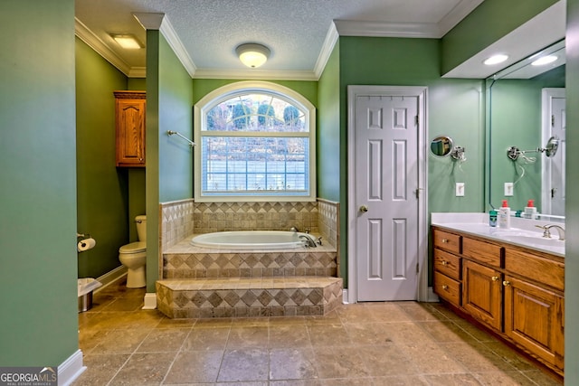 bathroom featuring a textured ceiling, vanity, toilet, ornamental molding, and a relaxing tiled tub