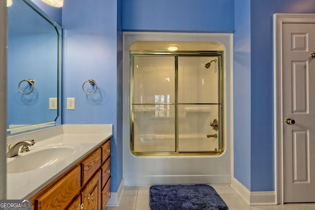 bathroom with tile patterned floors, vanity, and shower / bath combination with glass door