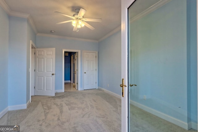 unfurnished bedroom with ceiling fan, crown molding, and light colored carpet