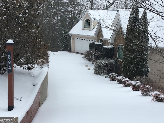 snow covered property featuring a garage