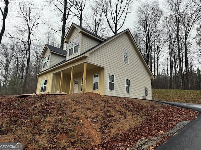 view of side of home featuring covered porch