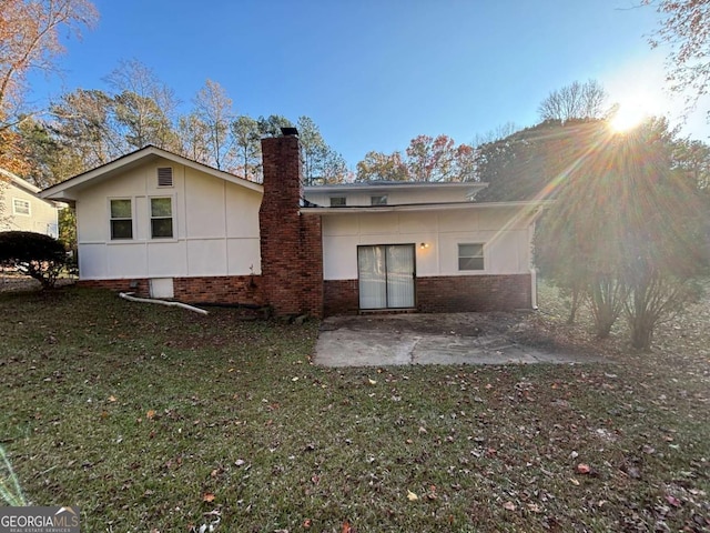 rear view of house featuring a lawn and a patio area