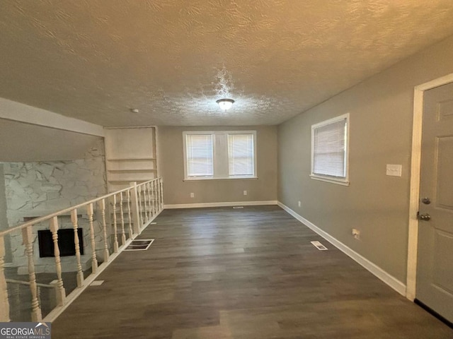 interior space with a textured ceiling and dark hardwood / wood-style floors