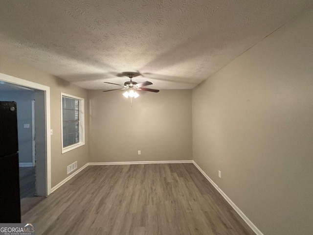 unfurnished room with a textured ceiling, ceiling fan, and hardwood / wood-style floors