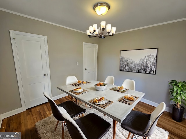 dining area with dark hardwood / wood-style flooring, a chandelier, and crown molding