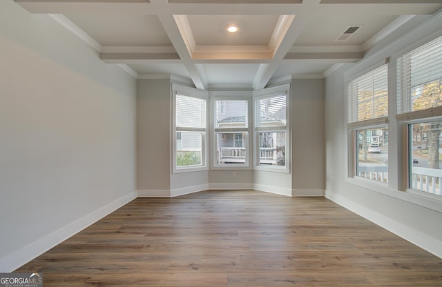 unfurnished room with hardwood / wood-style floors, beam ceiling, ornamental molding, and coffered ceiling