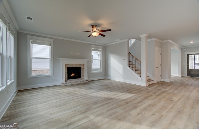 unfurnished living room with plenty of natural light, light hardwood / wood-style flooring, ceiling fan, and ornamental molding