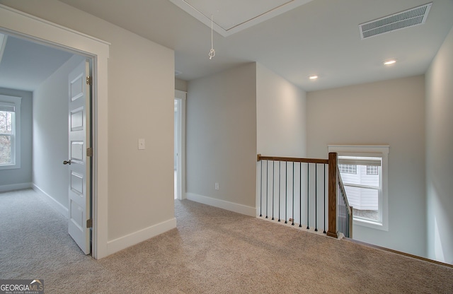 hall with light colored carpet and a wealth of natural light