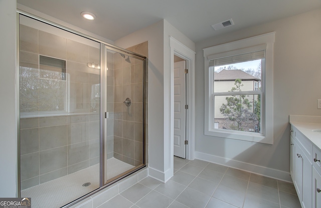 bathroom featuring tile patterned flooring, vanity, and a shower with door