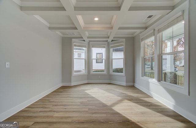 unfurnished sunroom featuring beamed ceiling, a healthy amount of sunlight, and coffered ceiling