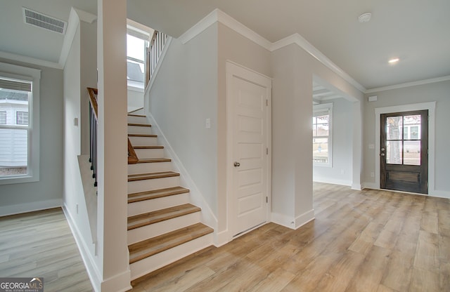 foyer featuring light hardwood / wood-style floors and ornamental molding