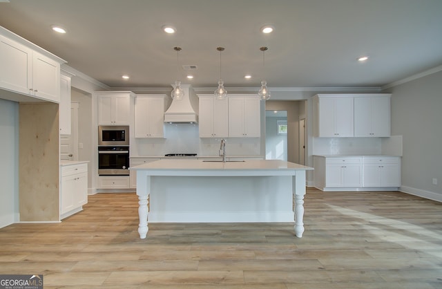 kitchen featuring built in microwave, stainless steel oven, sink, decorative light fixtures, and custom exhaust hood