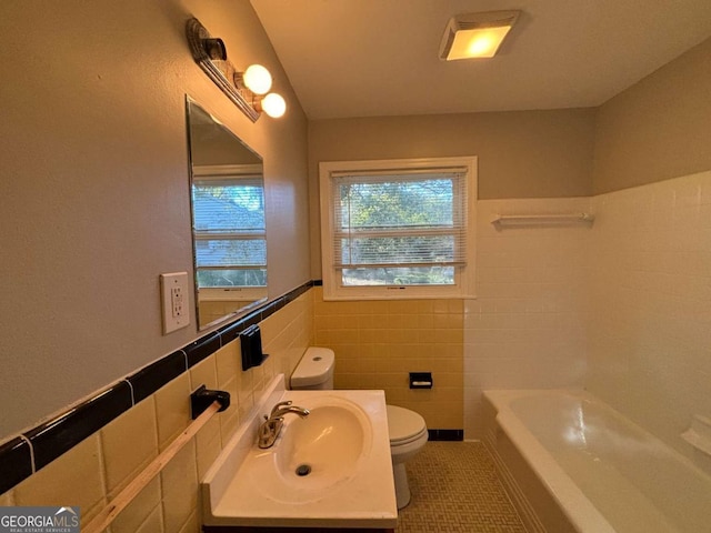 bathroom featuring toilet, a washtub, tile patterned flooring, tile walls, and vanity