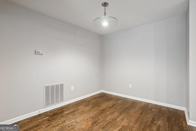 empty room with dark hardwood / wood-style flooring