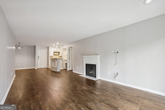 unfurnished living room with dark wood-type flooring