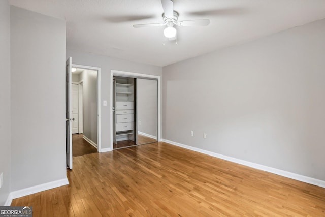 unfurnished bedroom with ceiling fan, wood-type flooring, and a closet