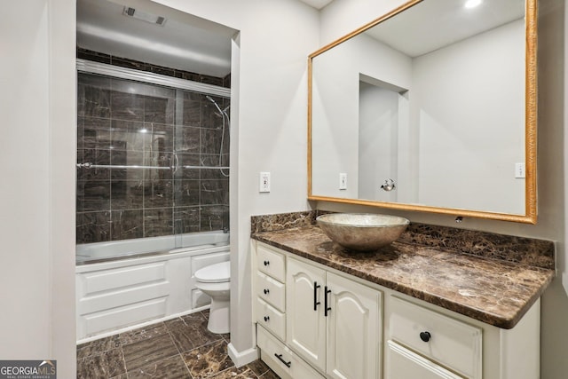 full bathroom with vanity, toilet, and enclosed tub / shower combo