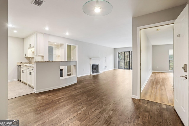 unfurnished living room featuring sink and hardwood / wood-style flooring