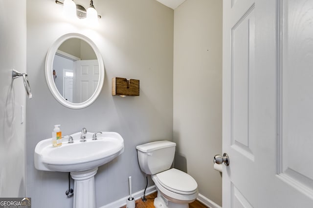 bathroom featuring wood-type flooring and toilet