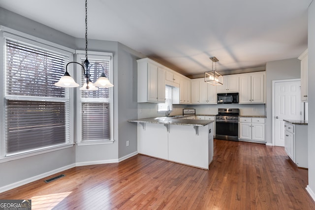 kitchen with pendant lighting, a kitchen breakfast bar, white cabinets, stainless steel range oven, and kitchen peninsula