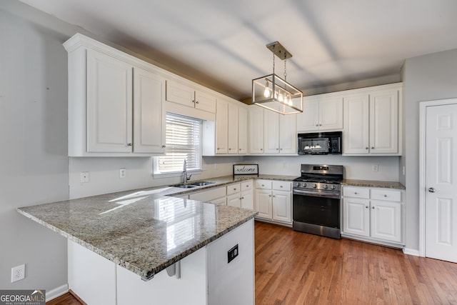 kitchen with pendant lighting, sink, white cabinetry, gas range, and kitchen peninsula