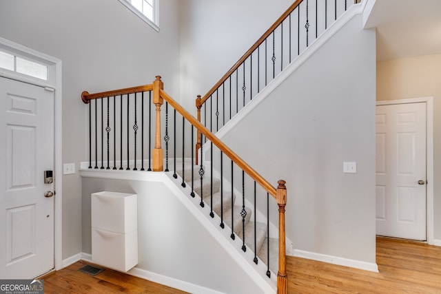 foyer with a high ceiling, plenty of natural light, and light hardwood / wood-style floors