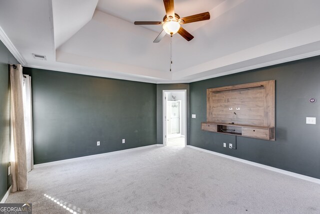 empty room featuring crown molding, carpet floors, ceiling fan, and a tray ceiling