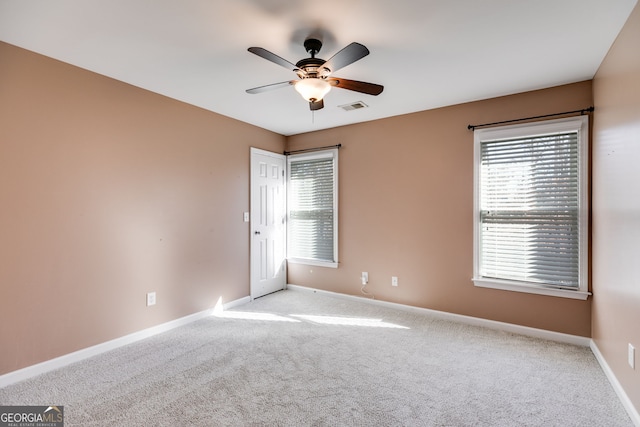 carpeted spare room with ceiling fan