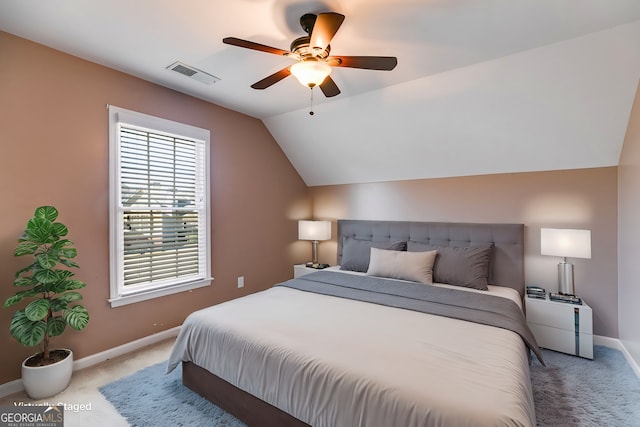 carpeted bedroom with ceiling fan and vaulted ceiling